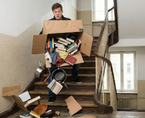 Ein billiger Umzugskarton reißt im Treppenhaus und alles fällt heraus