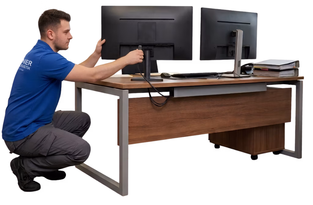 Ein Techniker von Wegener Umzugslogistik schließt einen Monitor bei einem Büroumzug an.